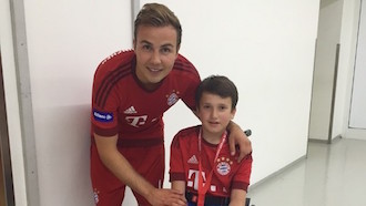 Mario Götze takes a picture with a child in a wheelchair