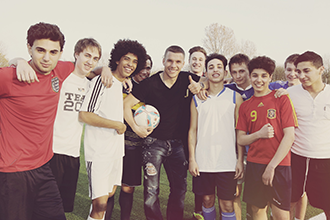 Lukas Podolski plays football with boys