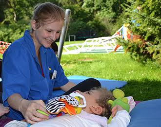 Pflegehelferin des Kinder-Hospiz Sternenbrücke mit einem Patienten