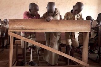 Afrikanischer Schüler mit Prothese während dem Schulunterricht 